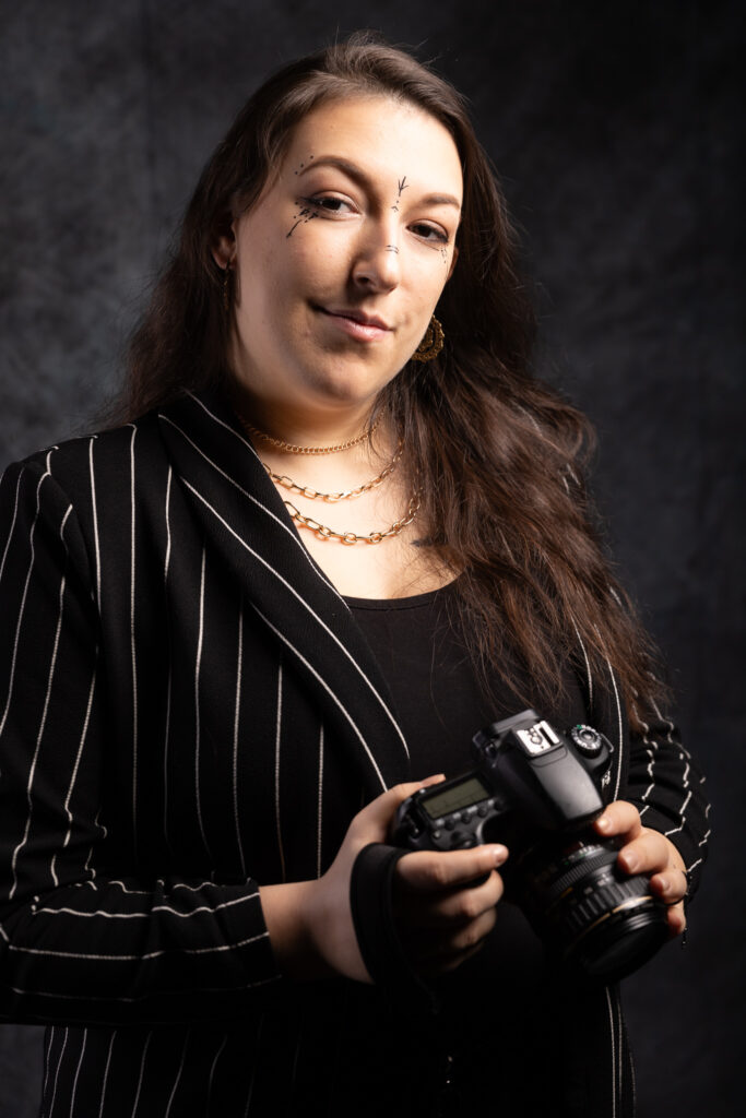 unedited studio portrait of a model with a camera