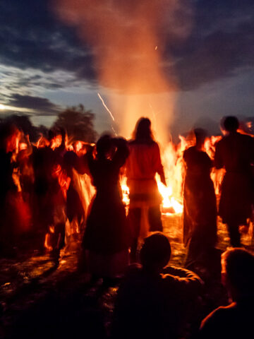 Norse and Slavic reenactors gather around a bonfire